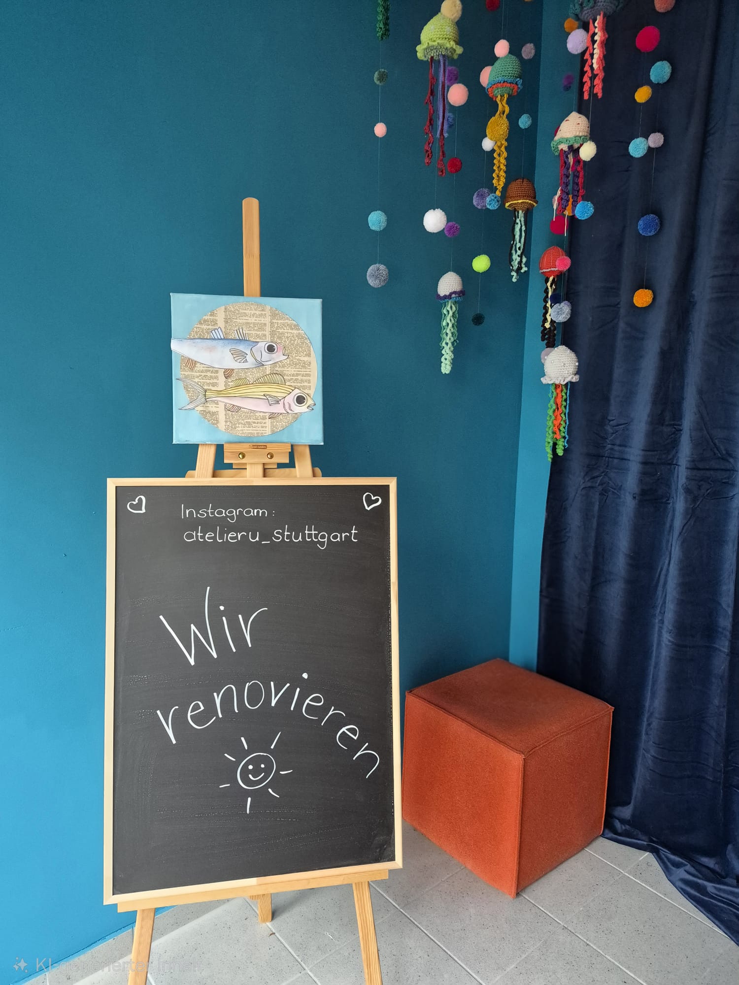 Staffelei mit Fischbild, Häkeldekoration und orangener Hocker